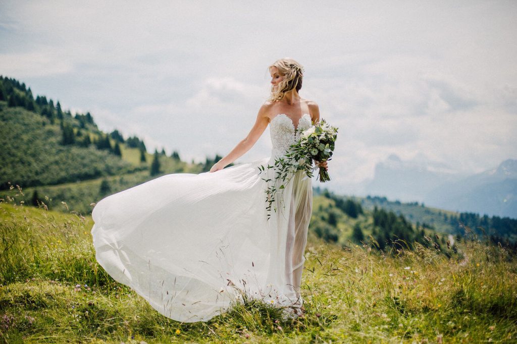 bride poses in wedding dress before wedding in the Alps