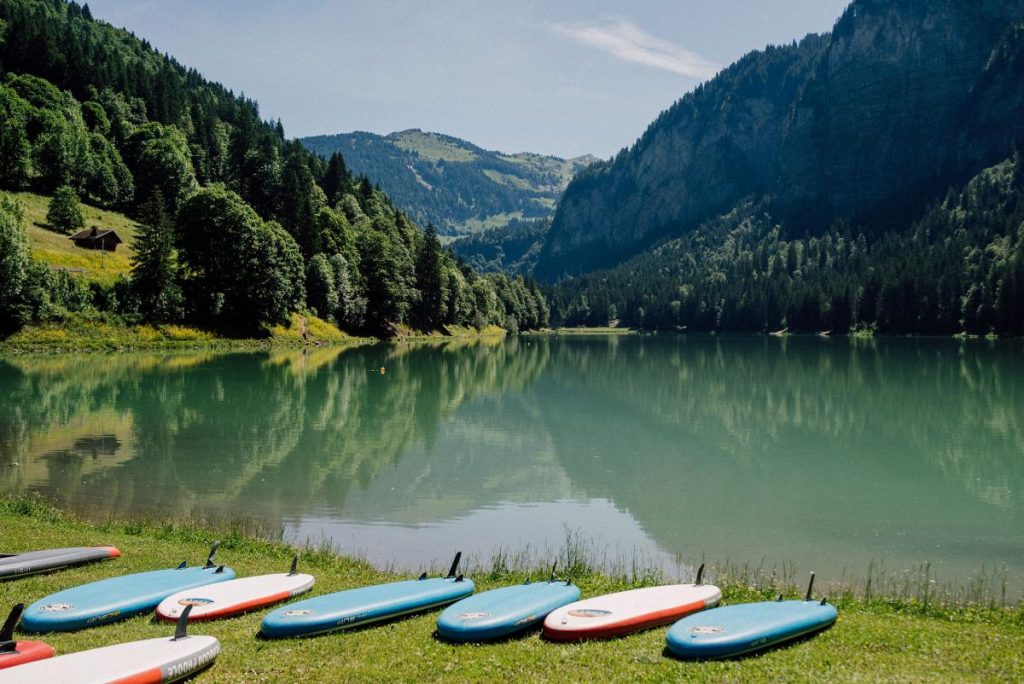 paddle boards on the shore of lake montriond, a beautiful alpine lake in morzine