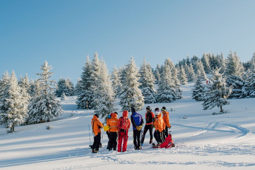 secours en montagne team discuss a rescue during training