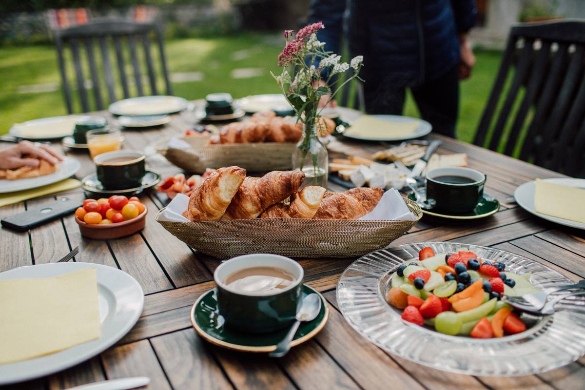 breakfast table with coffee, fruits and croissants during a yoga retreat 