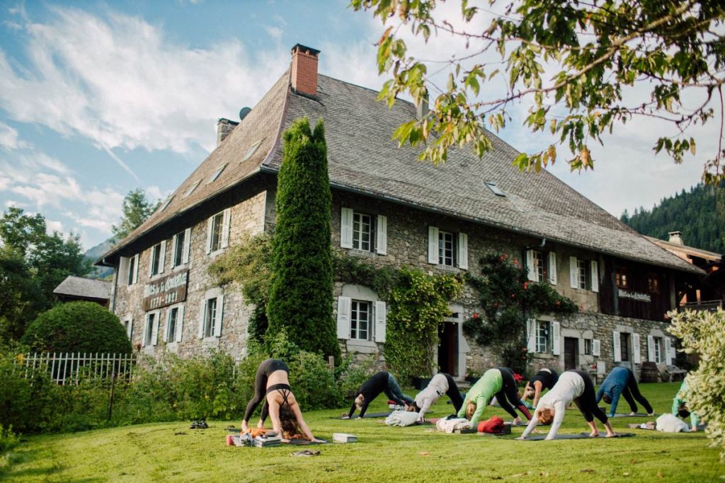 A group of people doing yoga in the garden of a hotel in Morzine